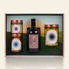 confezione regalo aperta che mostra 3 prodotti: 1 amaro e 3 vasetti sott'olio su sfondo beige